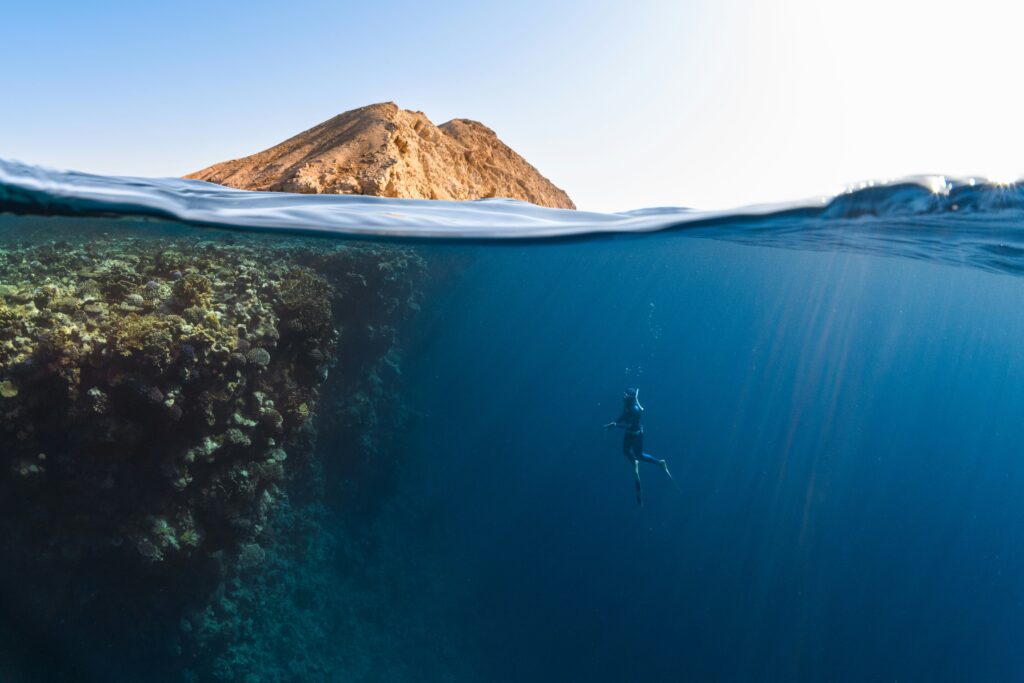 Digital Nomad adventures: Man Scuba Diving in deep blue water