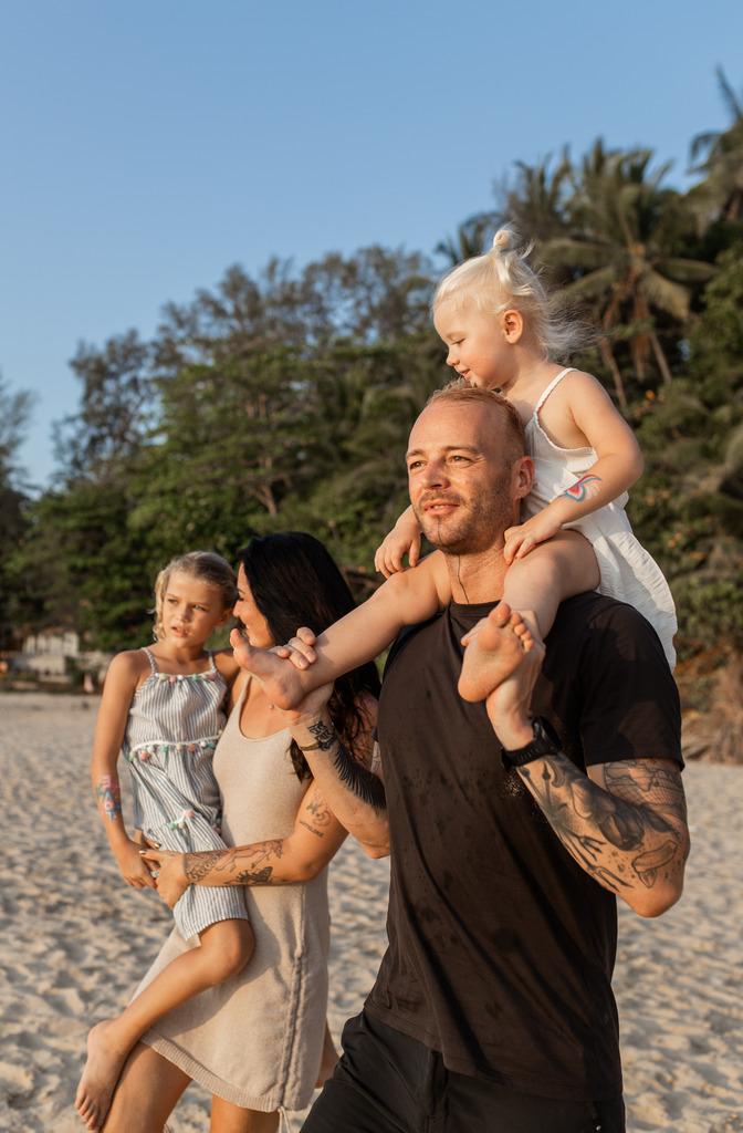 Family with two small daughters walking on the beach, Digital Nomad Mistakes