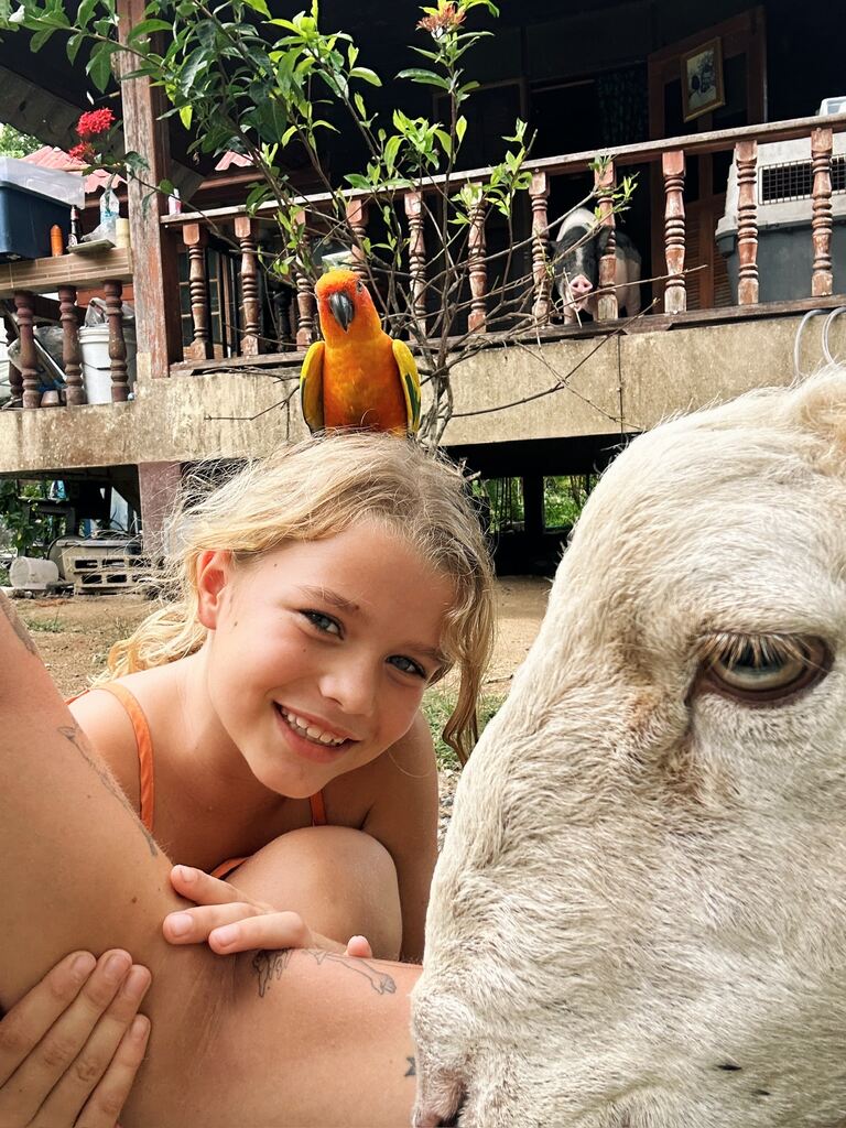 Young girl with a parrot on her head