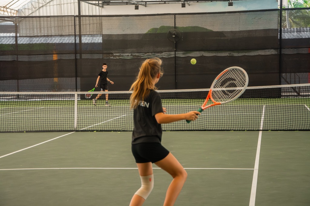 Two kids playing tennis