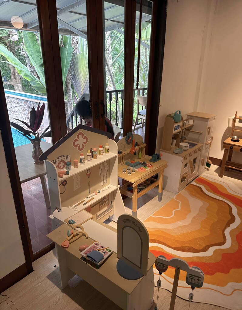 Wooden kids play corner with orange carpet.