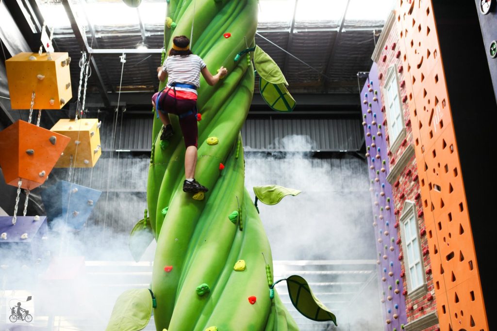 A kid climbing up an artificial plant. Best kids activities in Melbourne.