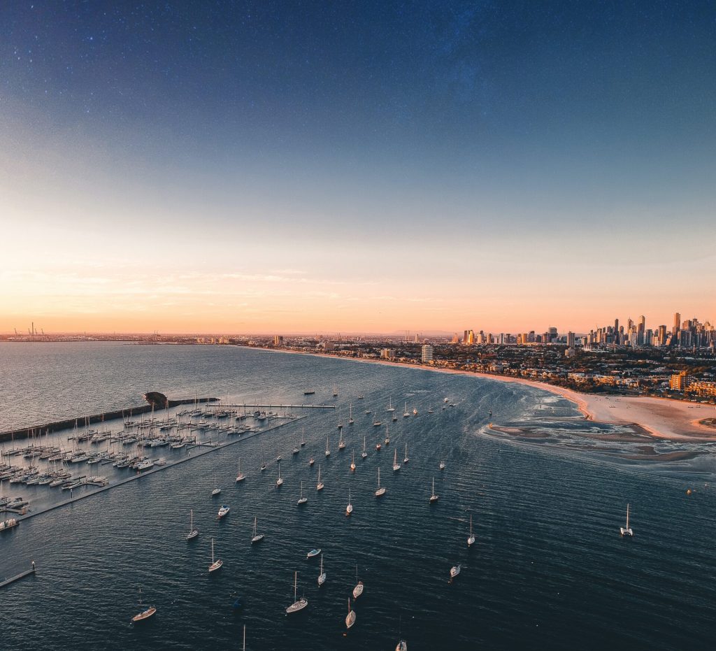 Aerial Shot of Melbourne Beach with boats at sunset time.