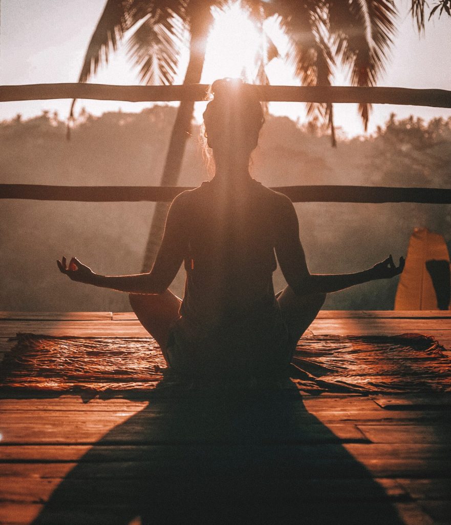 Women meditating from behind, healthy lifestyle as a digital nomad