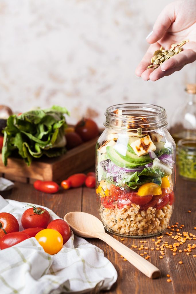 A glas full of different vegetables like lenses, tomatos, avocado and quinoa. Healthy Lifestyle as a digital nomad