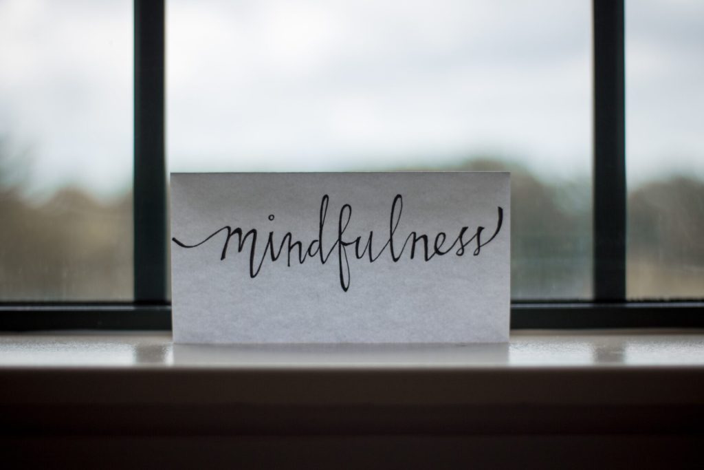 A white paper sign with the word "mindfulness" written onto it. Self discipline