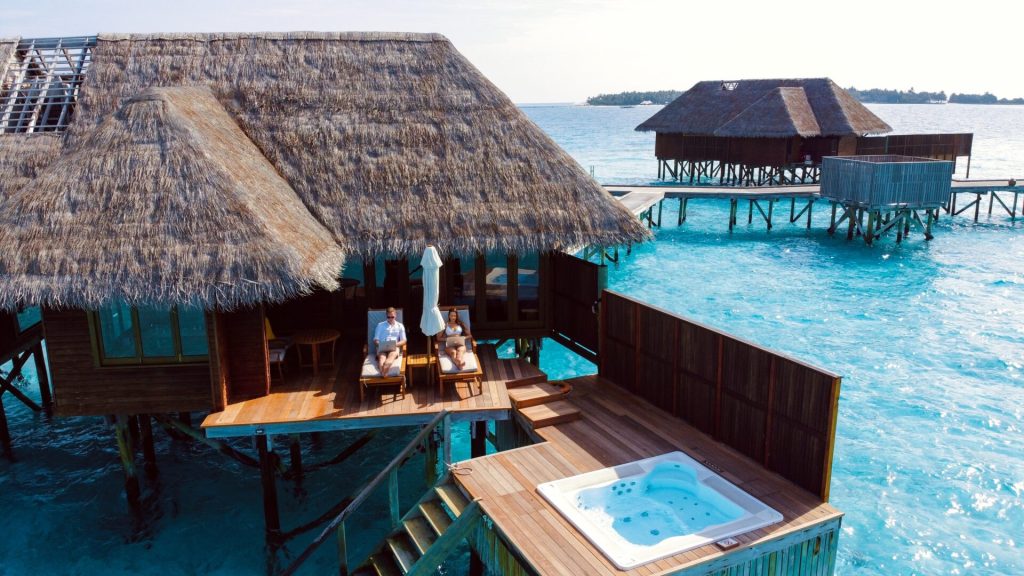 Carribean looking wooden houses directly sitting in turquoise water.