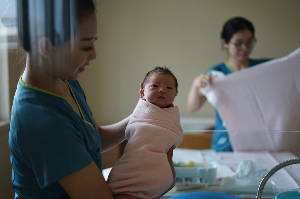 Giving birth in Thailand, A midwife holds newborn in hospital