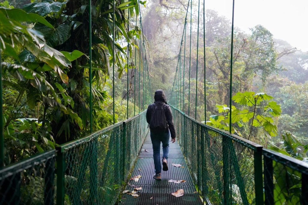 woman walking on a bridge in a jungle, costa rica digital nomad visa