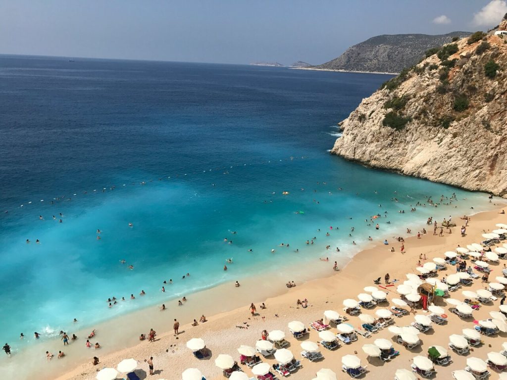 birds view on sea with turquoise water and beach with white umbrellas