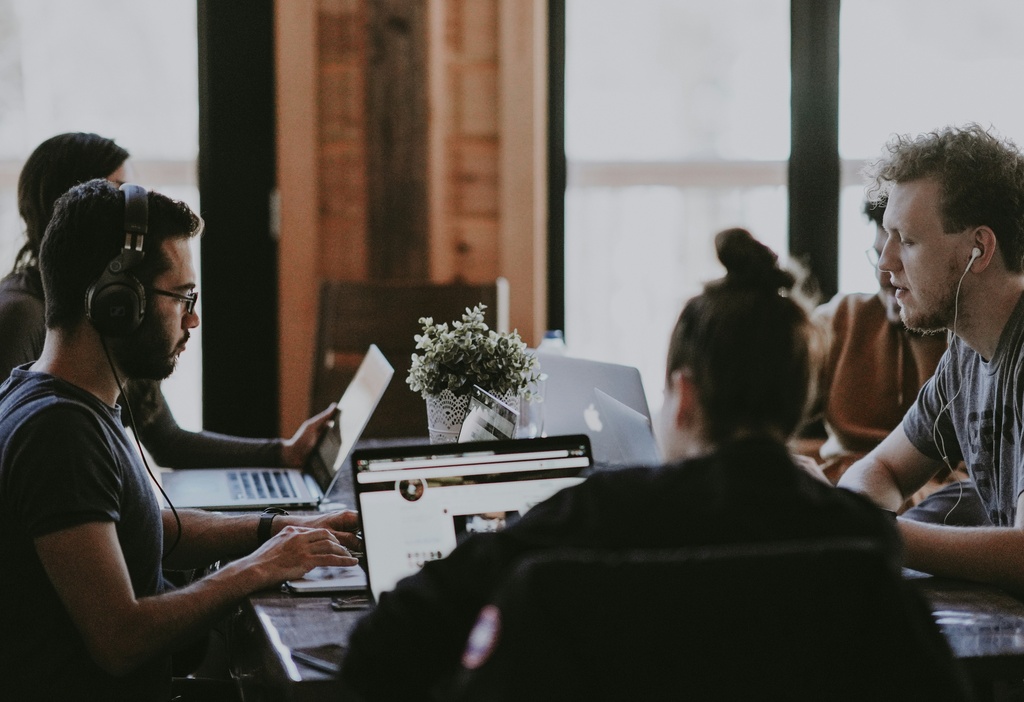 remote workers sitting on a table, working with headsets