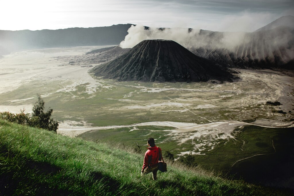 Hiking man, volcano in the background, How to travel around the world and make money