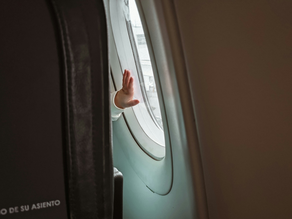 baby hand touching a window in an airplane