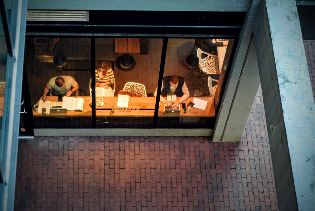 digital nomads working in a cafe, view from outside