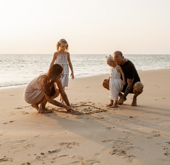 Family of four playing on the beach