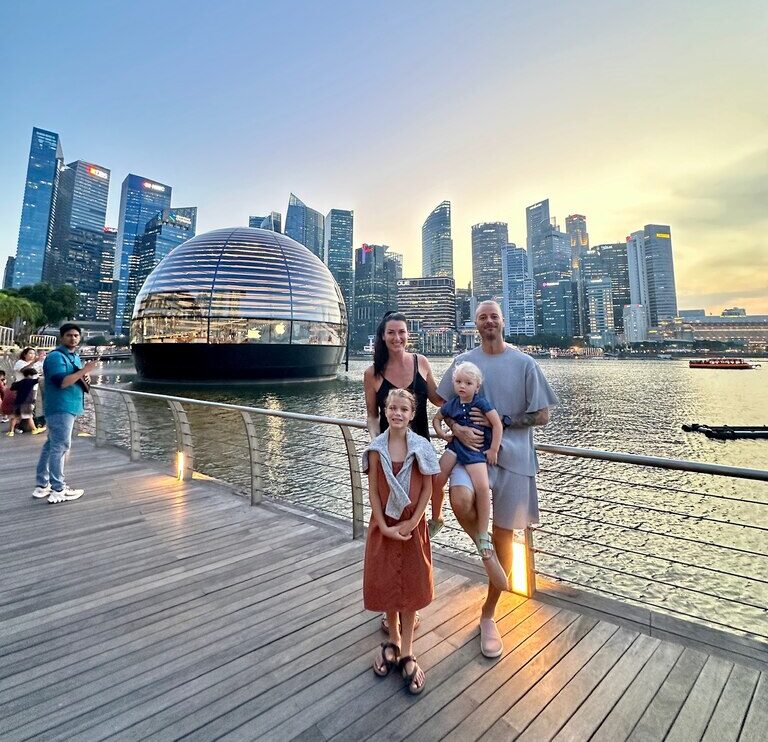 Family of four standing on a pier in front of big city skyline