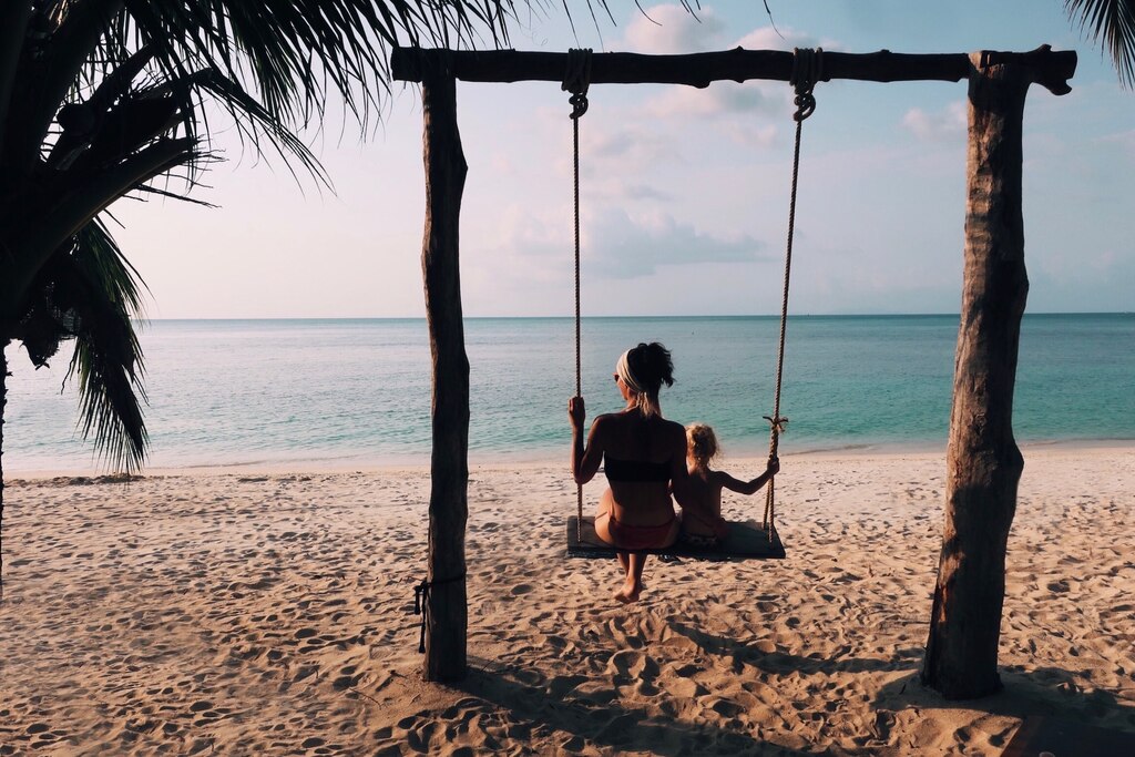 Woman sitting on a swing with daughter