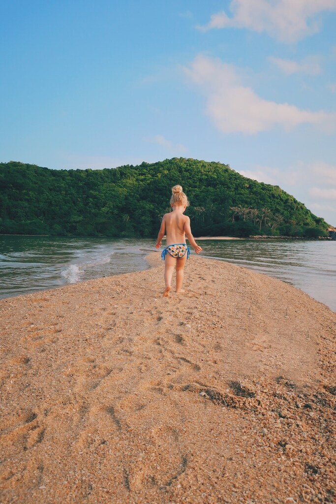 little girl walking along a sand bank