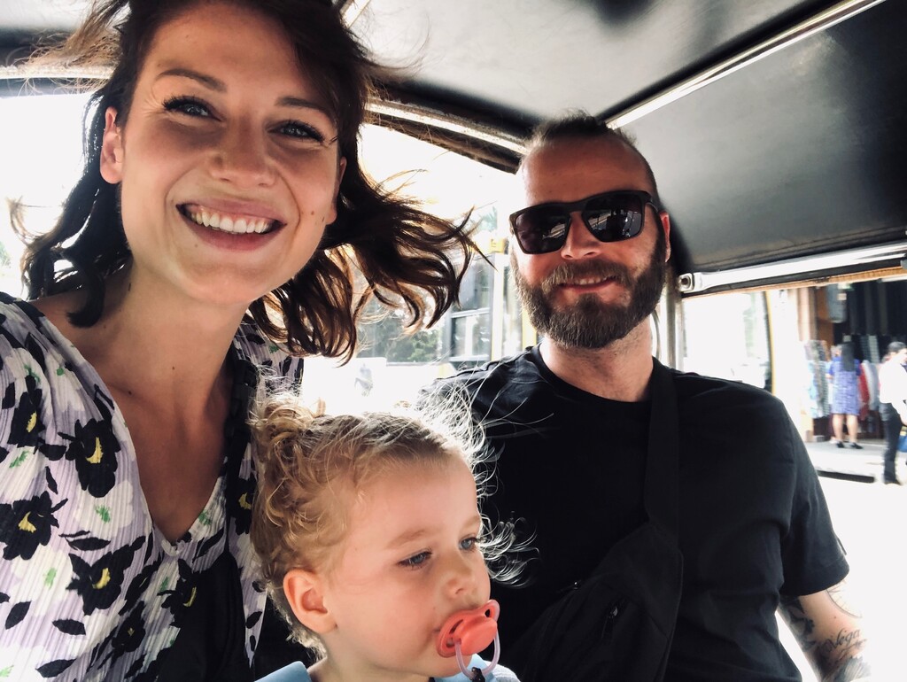 Family of three sitting in a tuk tuk, digital nomad with family