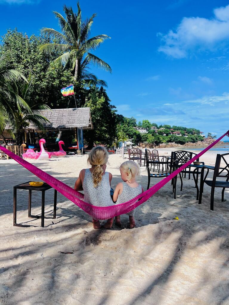 Two young girls sitting on a hammock together