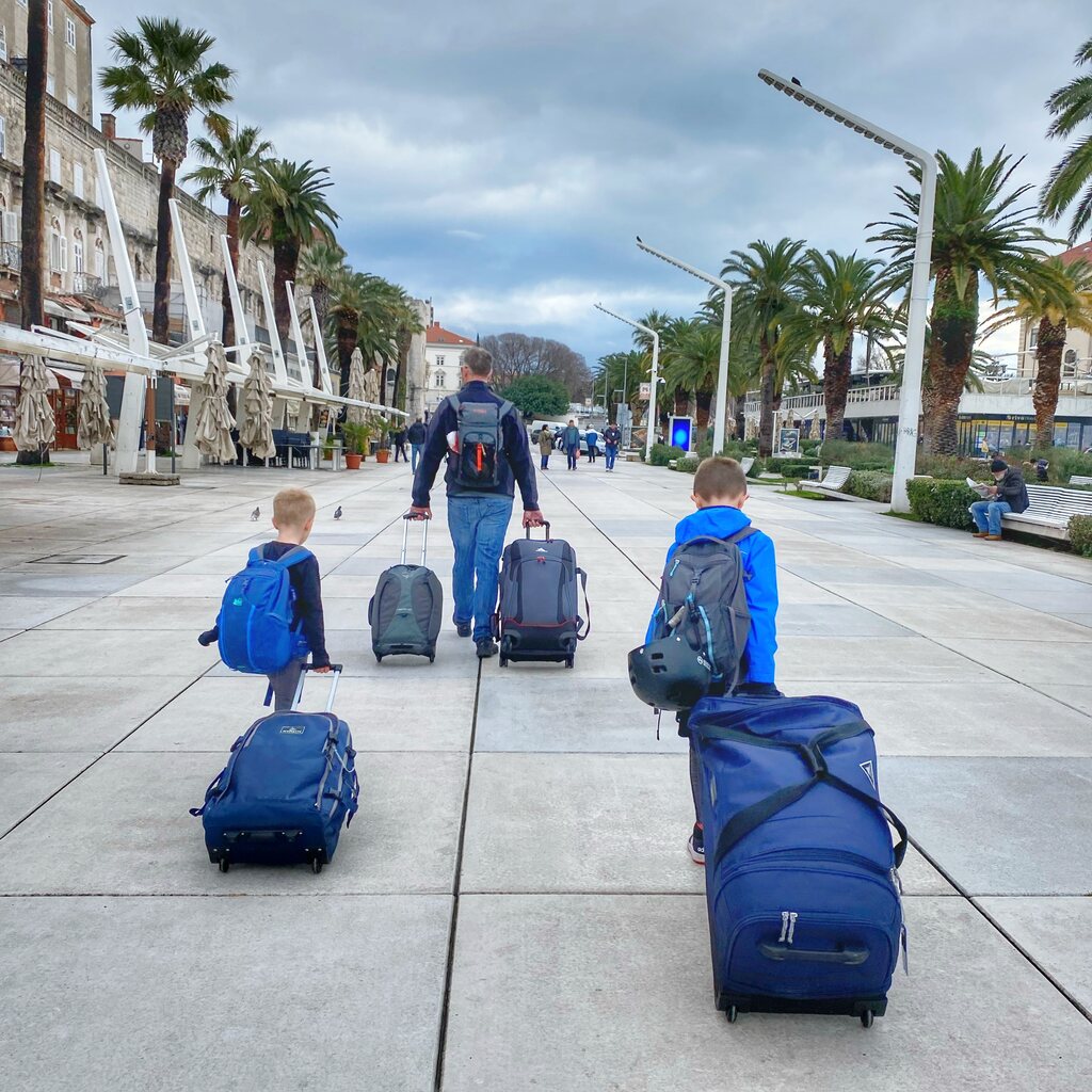 Father and two sons carrying luggage