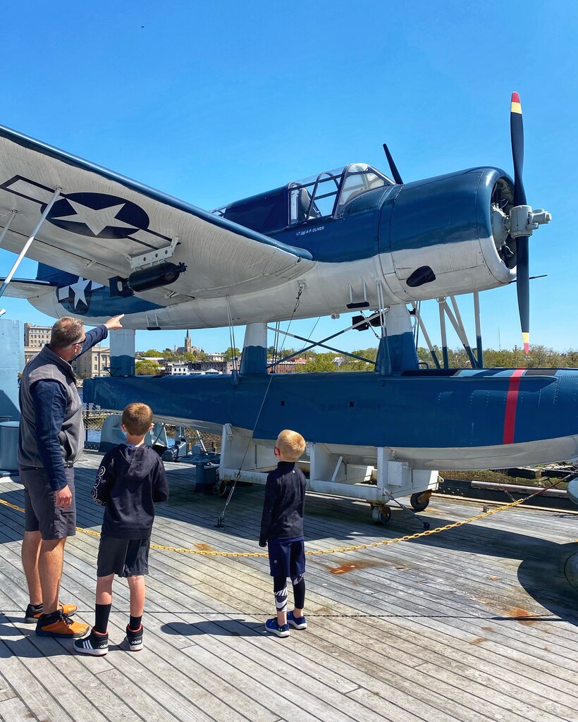 Father and two sons standing in front of an airplane