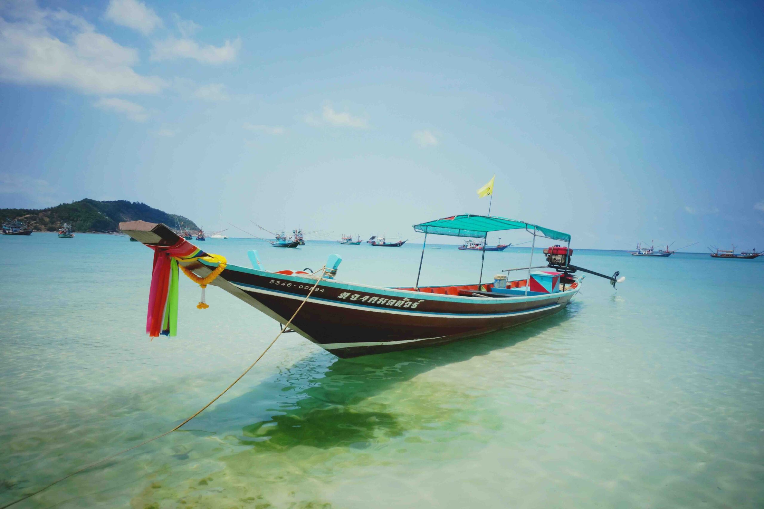 longtail boat with green roof in clear water