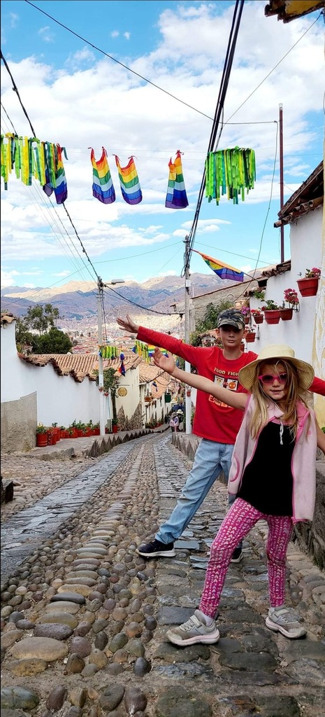 Two kids posing in front of colorful village