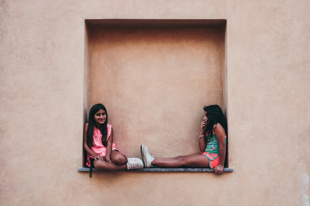 Two girls sitting next to each other