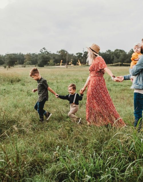 Family of five walking on a gras field, digital nomad families