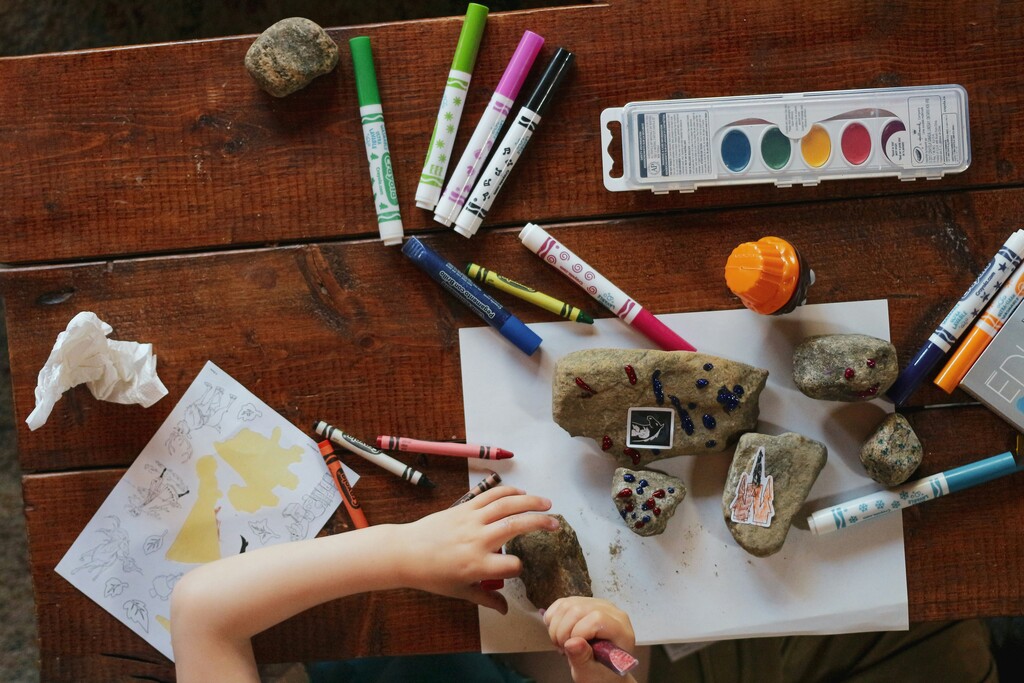 Kid playing with rocks and pens