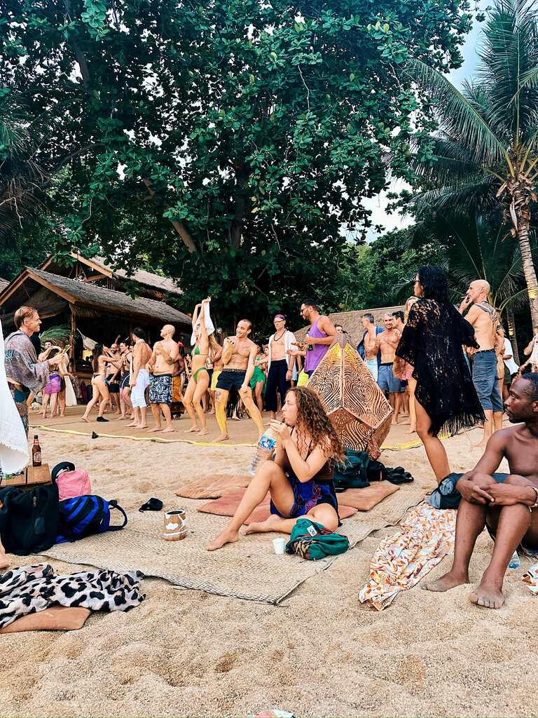 People sitting and dancing on the beach