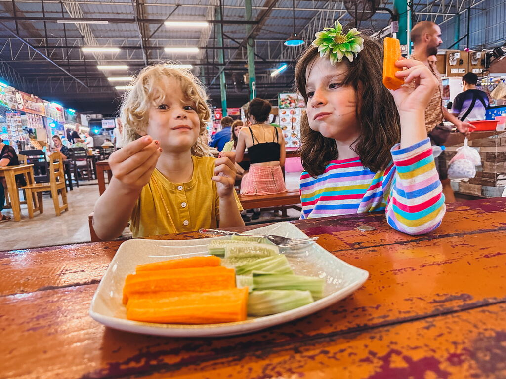 Two girls enjoying fresh cut veggies