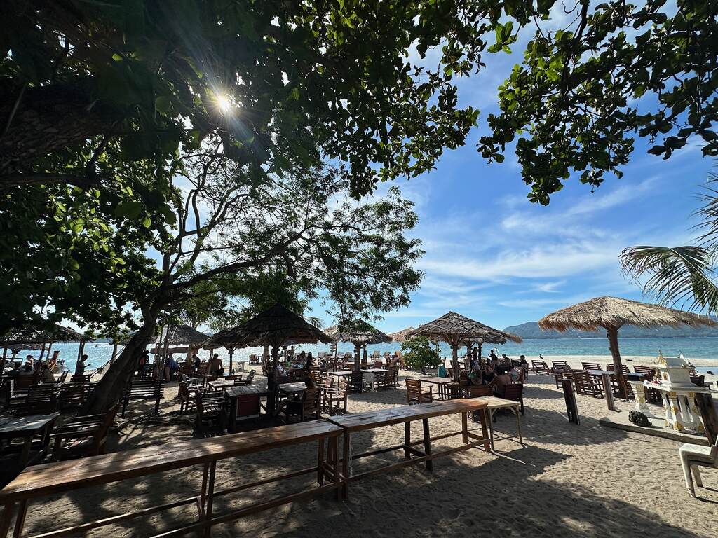 Bamboo Tables on the beach underneath large trees