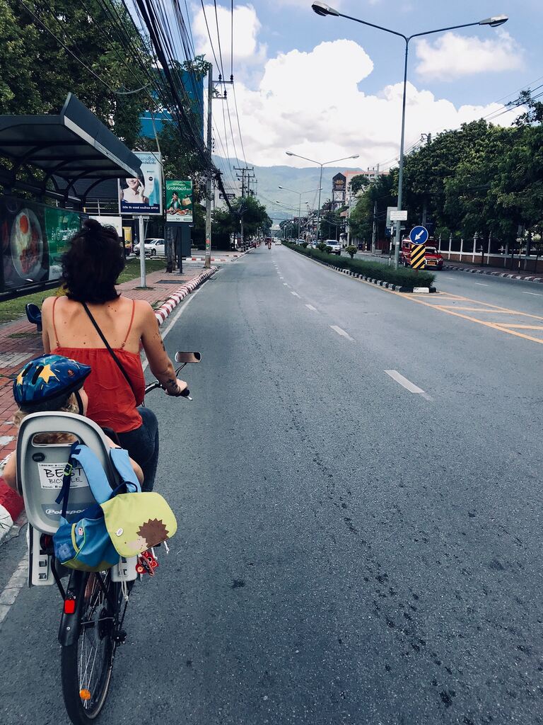 Mom and daughter riding a bicycle through Chiang Mai