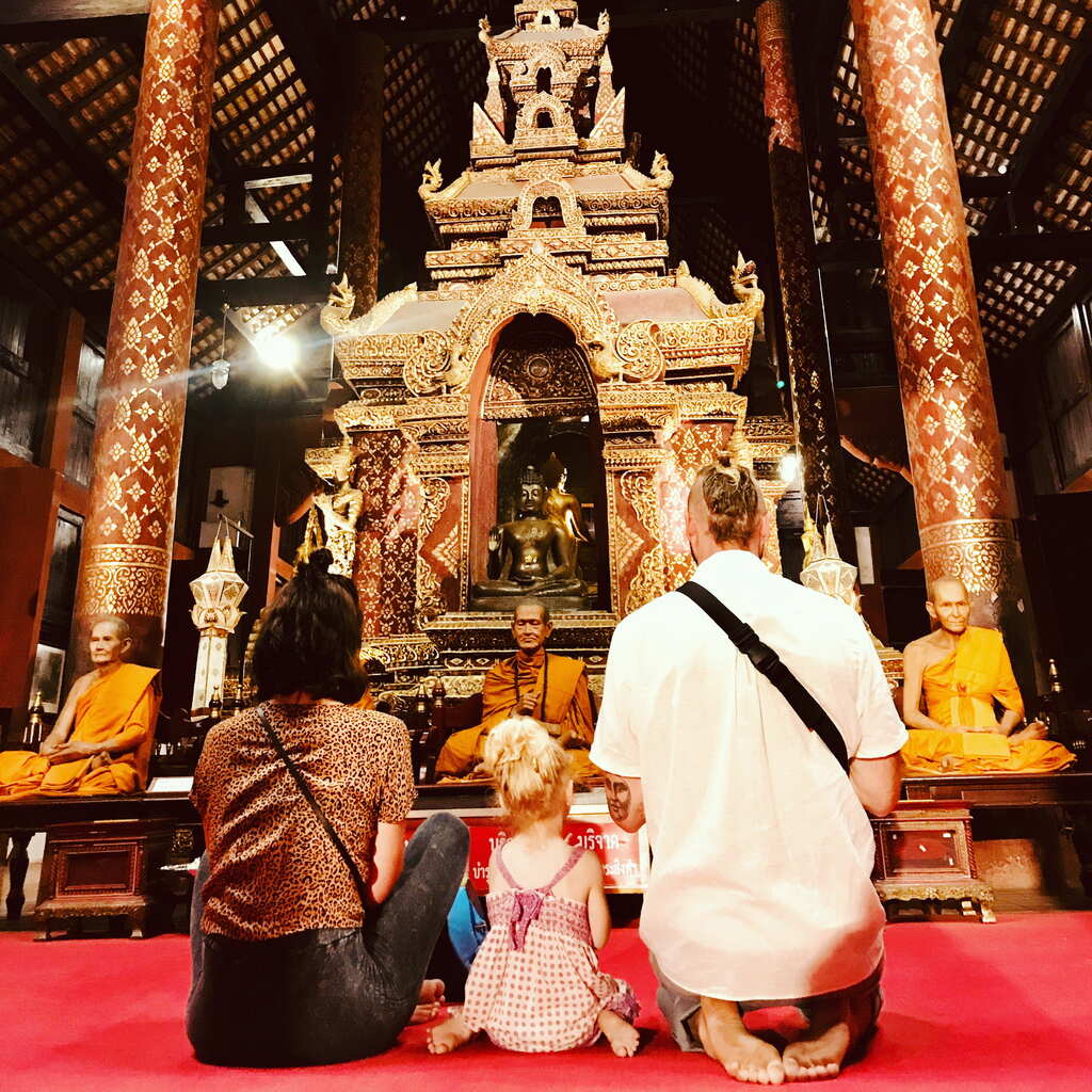 Family of three sitting in a Thai Temple