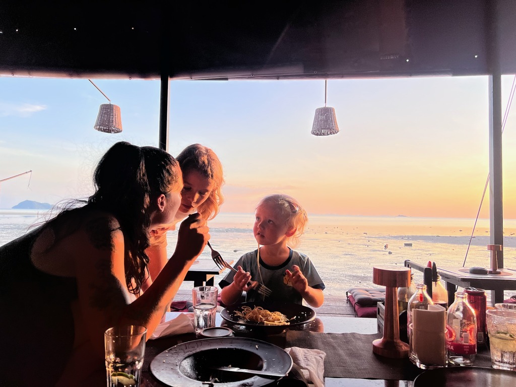 Family eating in a beach restaurant in Thailand