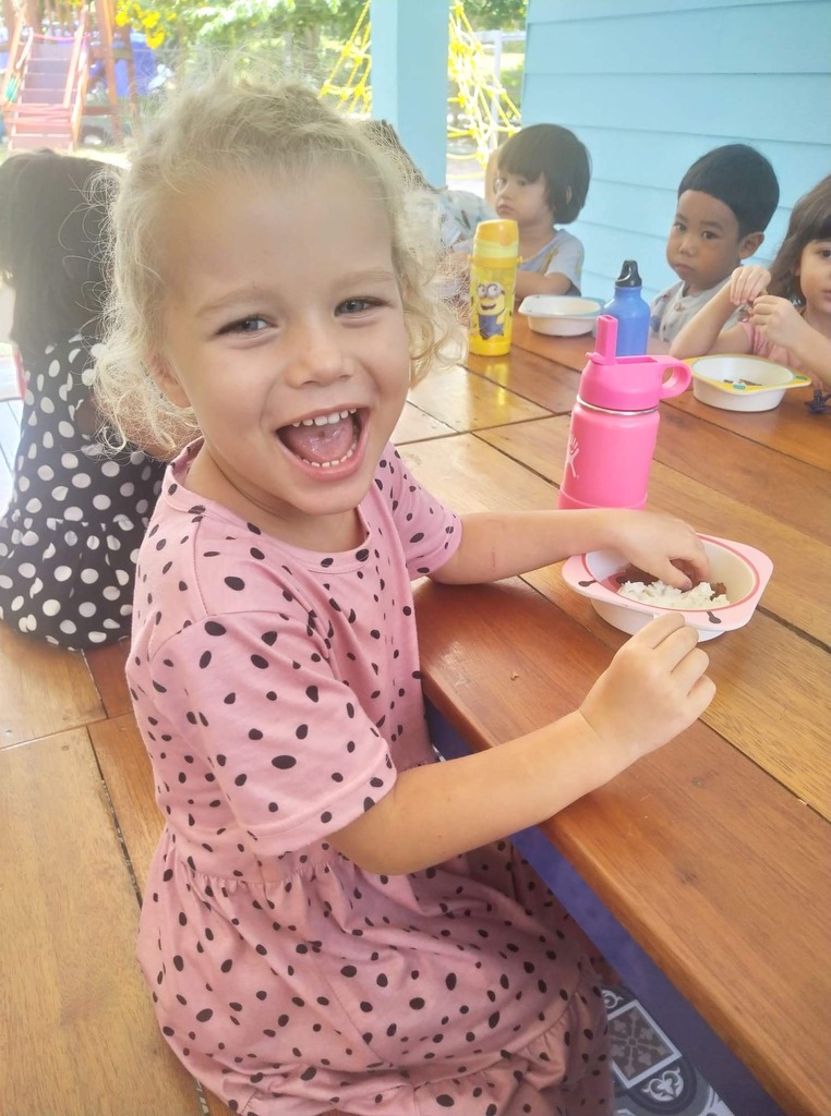 Little girl at school having lunch with her pals