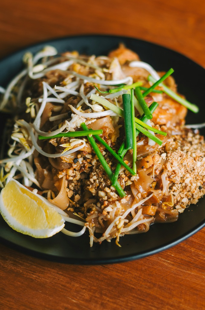 Noodle dish with fresh veggies and a sliced lemon