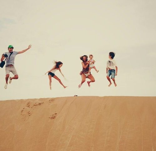 family of four jumping in the air in the desert