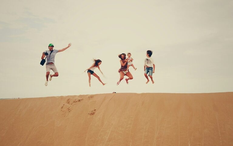 family of four jumping in the air in the desert