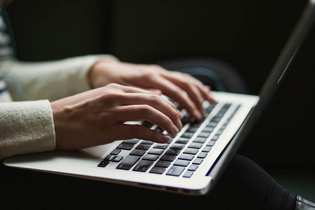 Hands writing on laptop