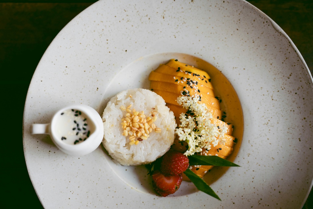 Mango, rice and strawberries on a white plate