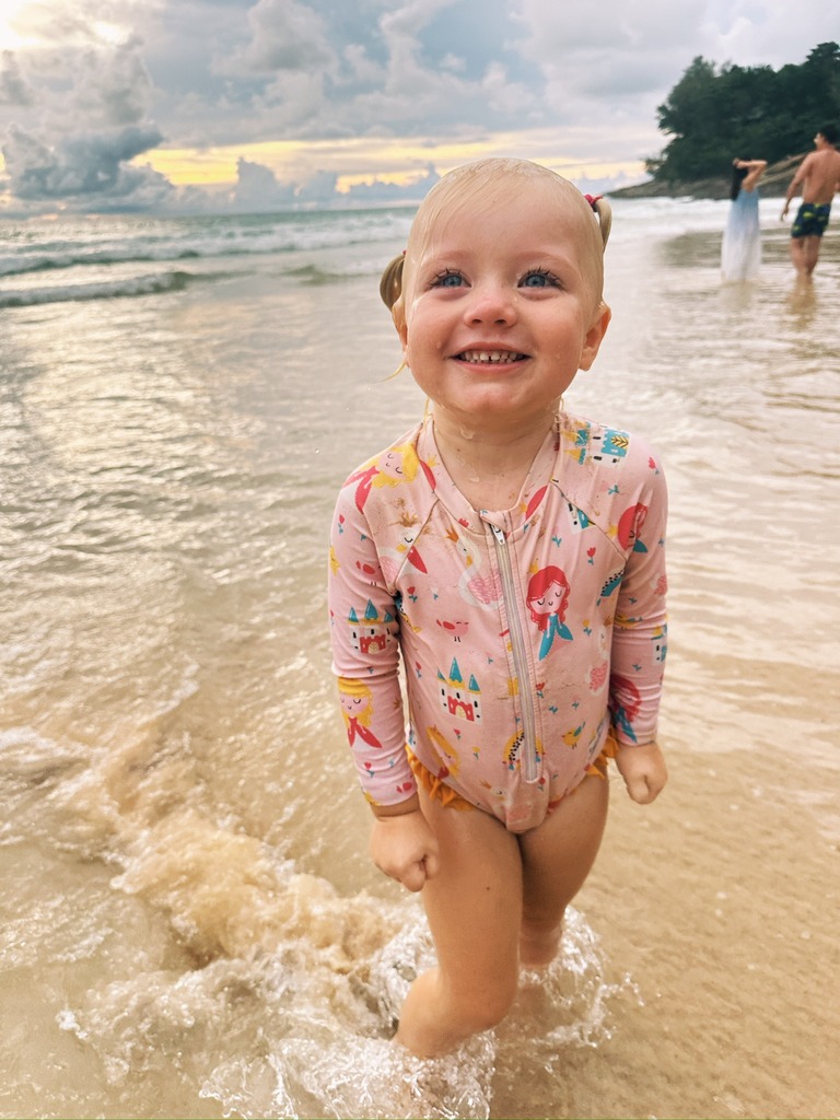 Toddler girl playing at the beach.