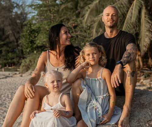 Family in Thailand sitting on the beach