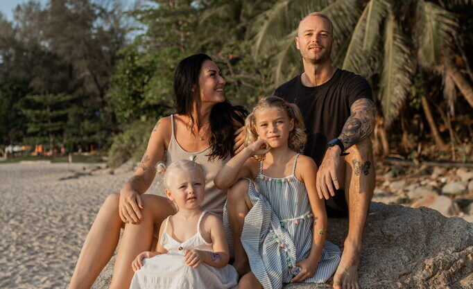 Family in Thailand sitting on the beach