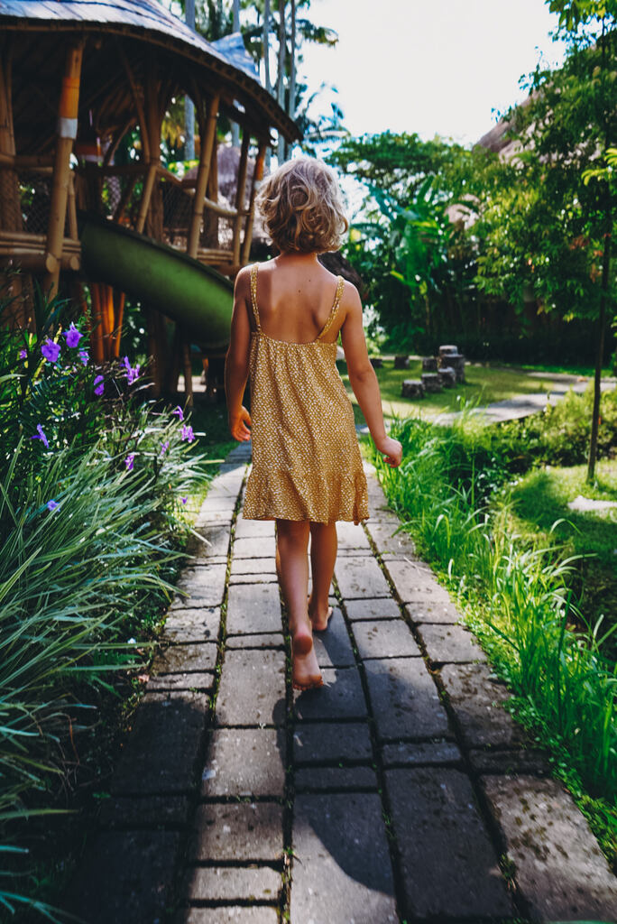 Girl in a lush garden, Living in Bali with kids