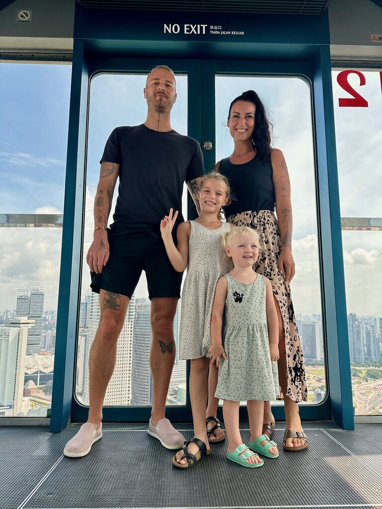 Family of four standing in gondola with city view in the background