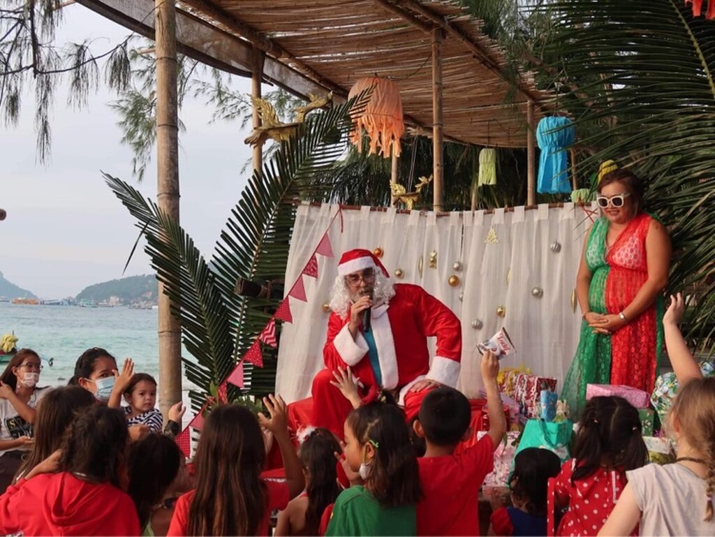 Santa Claus on the beach with kids waiting for their presents