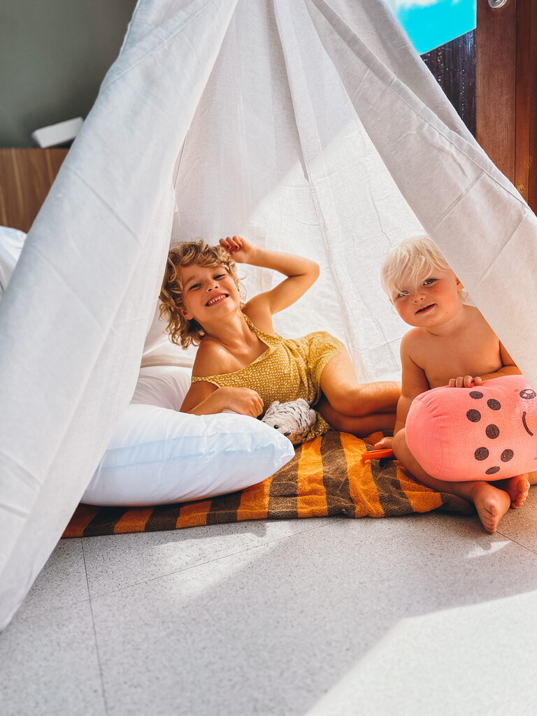 Two young girls playing in a white tent